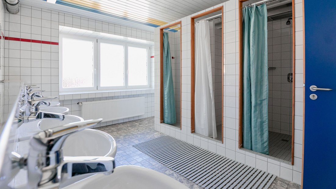 避暑别墅的白色瓷砖浴室，配有多个水槽和淋浴